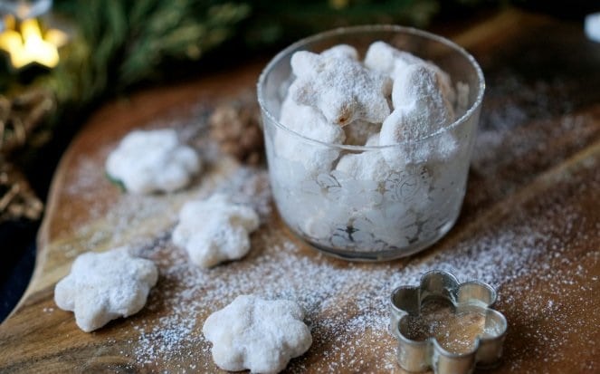 Křehké cukroví ze šlehačky ve tvaru hvězdiček, umístěných ve sklenici na dřevěné podložce.