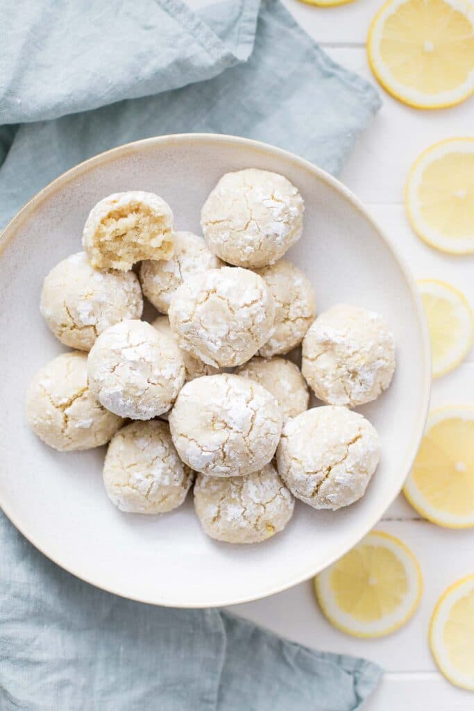 Citronové kuličky z bezlepkové mandlové mouky na talířku s kolečky citronu.