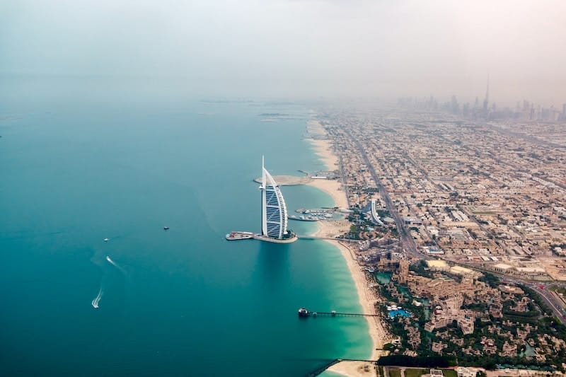 Dubai a jeho spojení pláží a luxusních resortů, s pohledem na ohromné město.