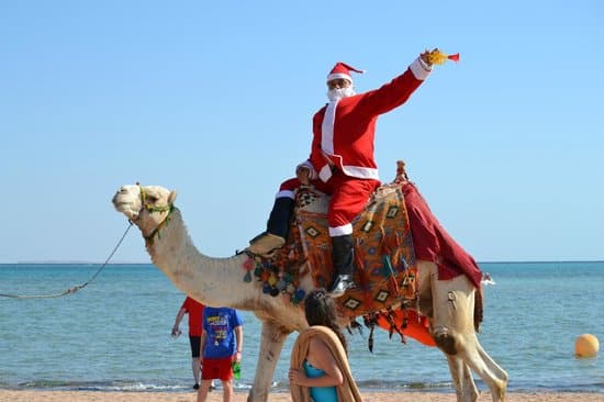 Netradiční Santa na velbloudu na poušti.